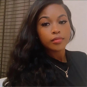 A selfie portrait featuring long wavy black hair, flawless makeup, and a delicate necklace.